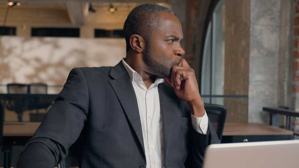 manager in an office looking concerned over a tough decision